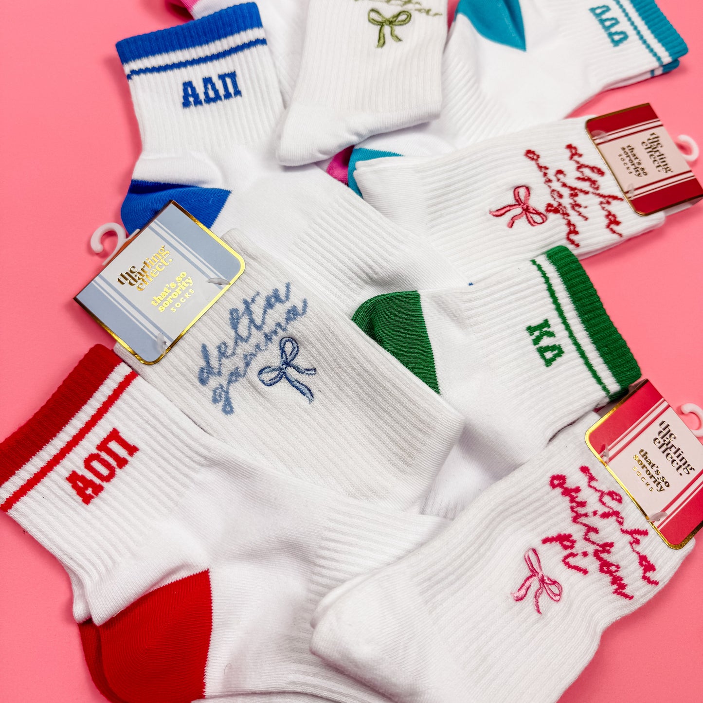 Collection of socks with various designs and text on a pink background