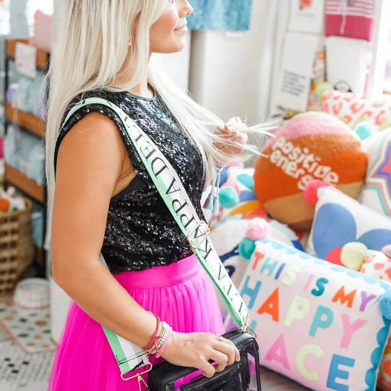 Woman holding a colorful bag in a store with various items and decorations around her.
