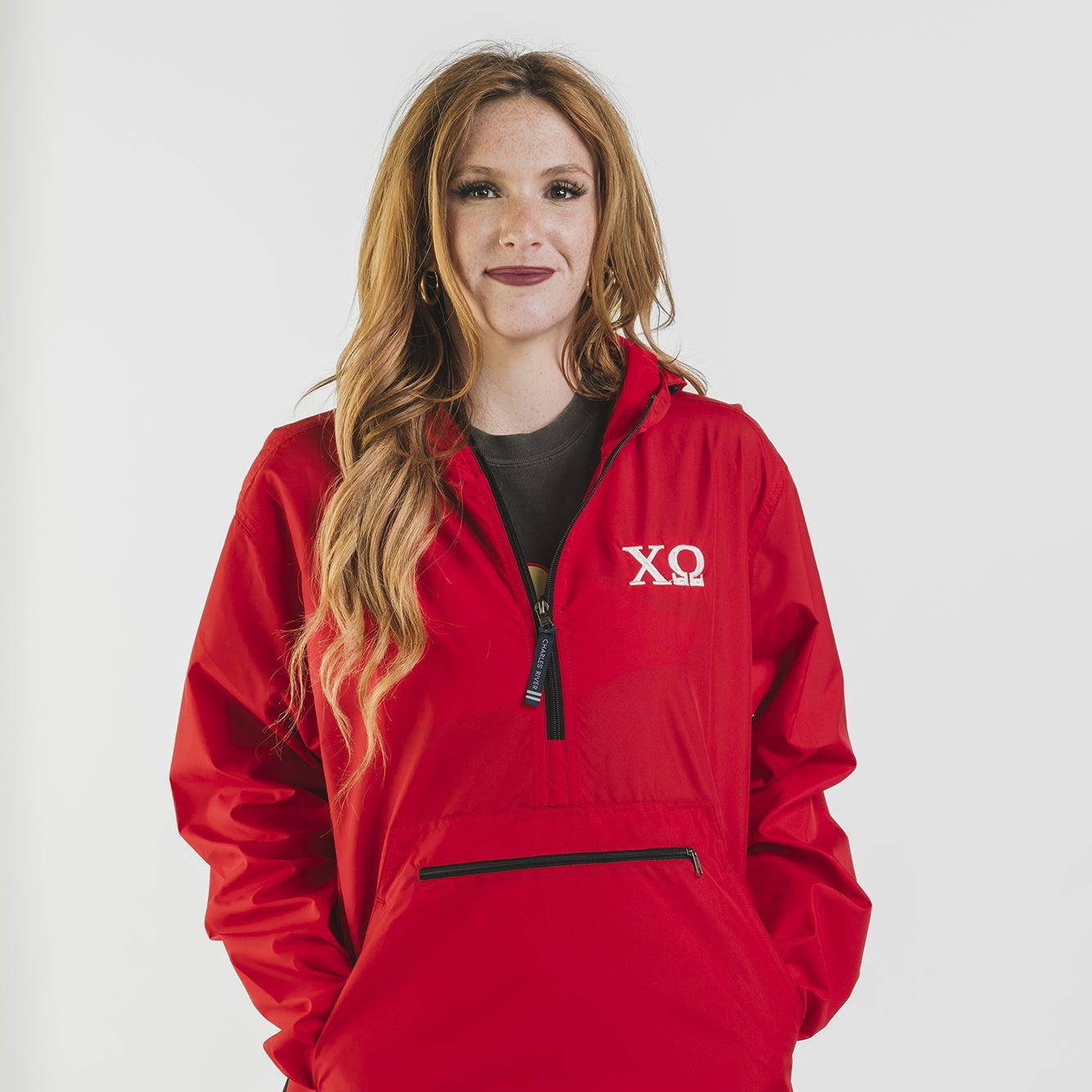 Person wearing a red jacket with a logo on a white background
